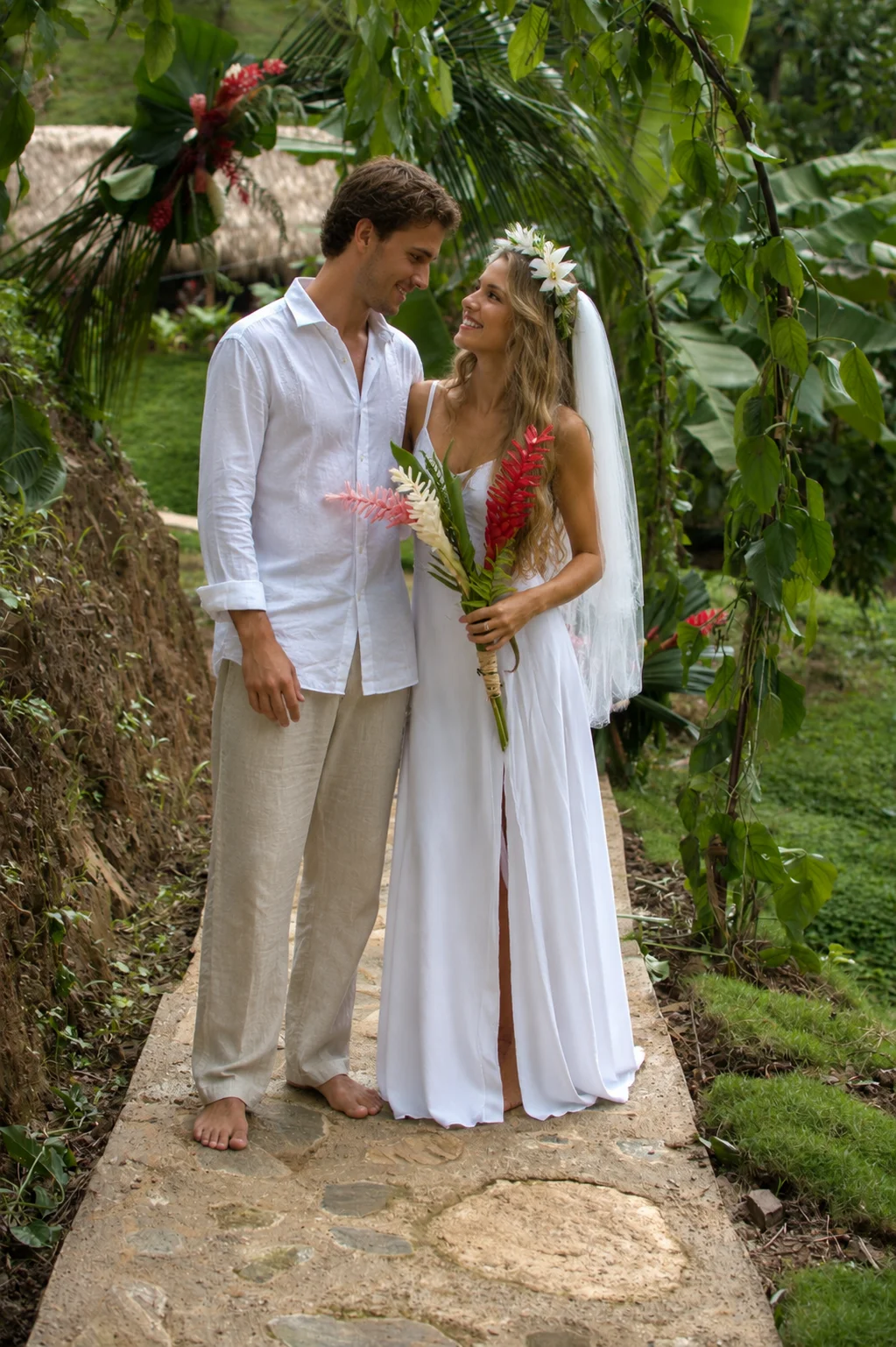 Bride and groom walking through lush tropical gardens at Promised Land Tayrona, a luxury destination wedding venue in Colombia.