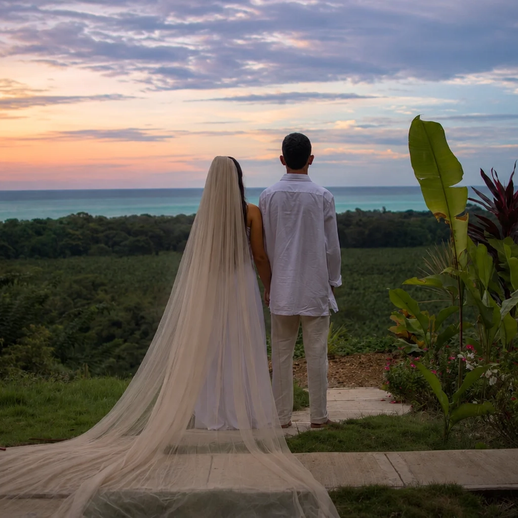 Bride and groom overlooking the Caribbean Sea at sunset during a destination wedding at Promised Land Tayrona, Colombia.